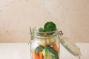 Frozen vegetables in a glass jar. Tasty and healthy food. The concept of vegetarianism.