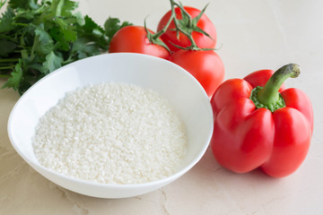 Raw rice and vegetables. Ingredients for cooking stuffed peppers.