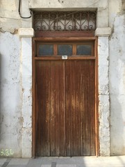 Old vintage entrance in family house, wooden door brown color and clear white bricks in wall. 