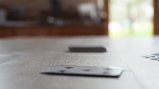 2 teenagers, boy and girl, play cards on a wooden table