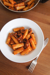 Tortiglioni pasta with tomato and beef on white plate 