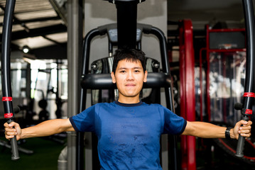 Asian man is training fitness in gym.