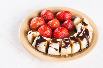 Fresh strawberries with sliced banana and topped chocolate cream