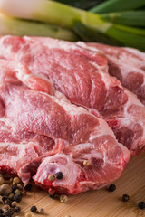 Several slices of neck pork steak with pepper seeds and vegetable