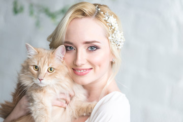 Young beautiful bride with a cat in her arms, the morning before the wedding