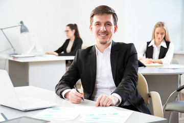 Fototapeta premium Young businessman using computer in the office