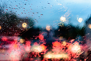 Fototapeta na wymiar Abstact and bokeh background. Rain drops on car window in rainy season. raining car driving concept.