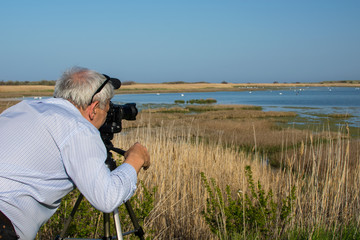 Man birdwatcher shoots video of birds in Shablaenska Tuzla - Via Pontica natural reserve