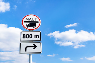 Schild Mautpflicht mit Entfernungs- und Richtungsangabe