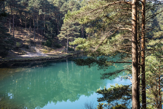 Beautiful vibrant landscape image of old clay pit quarry lake with unusual colored green water