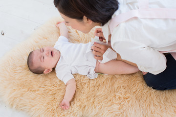 おむつを替えてもらう赤ちゃん