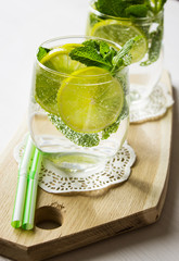 Homemade lemonade with lemon and mint on a wooden board. Selective focus. Vertical.