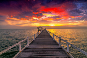 Wooden bridge in the sea at sunset