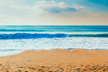 Sand beach and ocean wave under blue sky