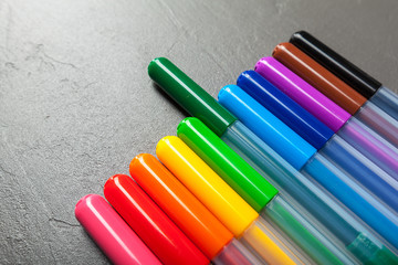 Colorful felt pens on the dark stone background top view