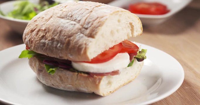 Fly out reveal ciabatta sandwich with speck, mazzarella and vegetables, 4k 60fps prores footage