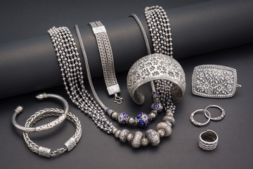 Collection of antique traditional silver jewelry on black paper - obrazy, fototapety, plakaty