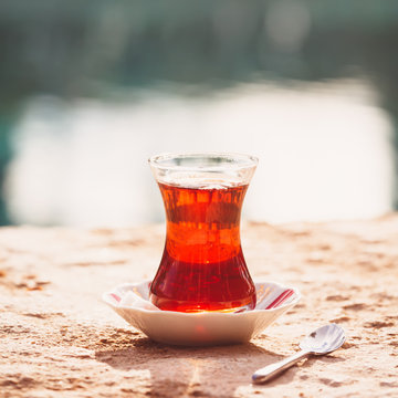 Hot turkish tea outdoors near water. Turkish tea and traditional turkish culture concept