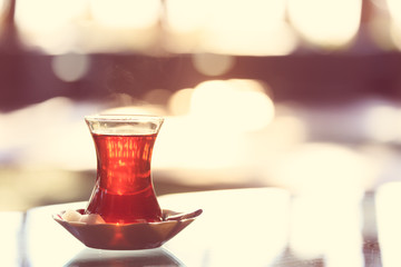 Hot turkish tea outdoors near glass wall. Turkish tea and traditional turkish culture concept - obrazy, fototapety, plakaty