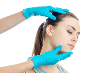cosmetologist touches the face of a young girl with gloves is isolated on a white background