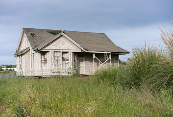 Abandoned single family home with wooden siding as fixer upper property