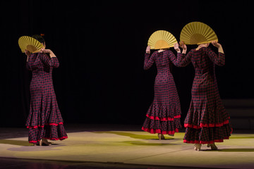 RUSSIA, RYAZAN - DECEMBER 11, 2016: V RUSSIAN FESTIVAL FLAMENCO. Three women in dresses in a cage with fans.