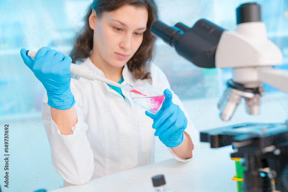 Poster Young woman in microbiological laboratory.