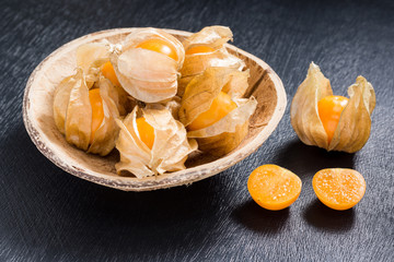 cape gooseberry fruit in coconut shell dish