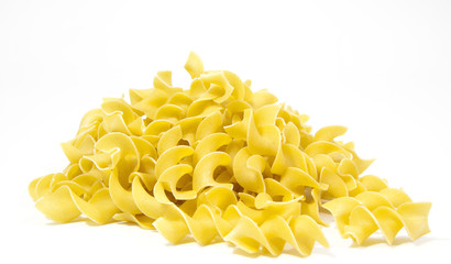 Mound of uncooked yellow egg noodles. Isolated.