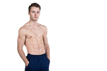 Fototapeta premium Healthy lifestyle and fitness. Handsome guy sports physique, with a naked body, on the left side of the frame, isolated on a white background. Horizontal frame