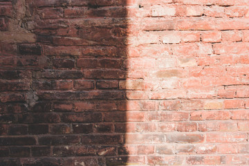 Old red brick wall with shadows background