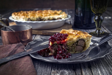 Vanison Pie with Cranberry Relish as close-up on a pewter plate