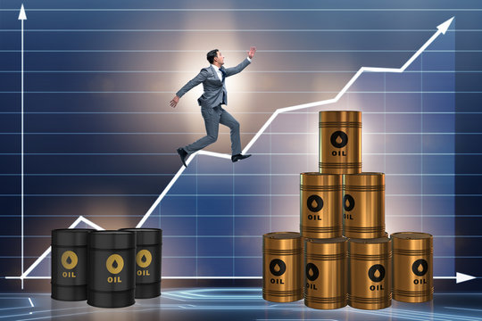 Businessman jumping from stack of oil barrels