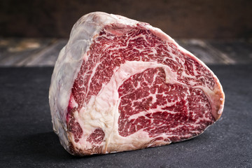 Raw dry aged Black Angus Entrecote Steak as close-up on a slate - obrazy, fototapety, plakaty