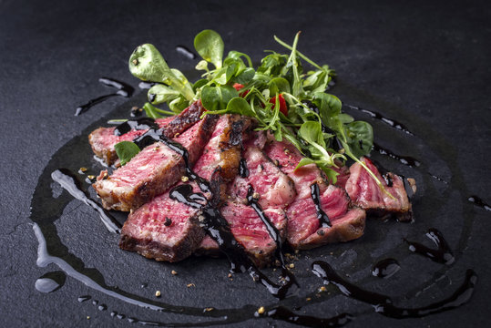 Barbecue Wagyu Tagliata di Manzo mit Feldsalat als close-up auf einer Schieferplatte