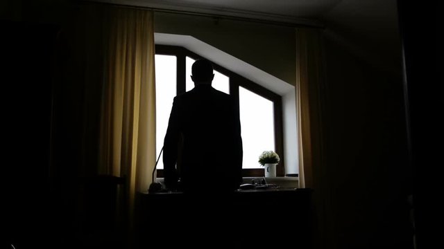 silhouette of a man dressed in the room