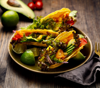 Corn tortilla tacos with avocado, tomatoes, onion and lettuce