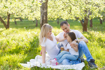 Fototapeta premium Happy family of three having fun in the park