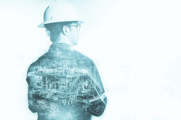 Double exposure of Engineer or Technician man with safety helmet operated platform or plant by using tablet with offshore oil and gas platform background for oil and gas business concept