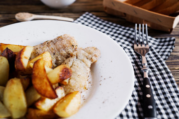 Delicious dinner, fast food, a national dish, fish with fried potatoes, fish and chips, sauce and white toast bread on a dark wooden background 