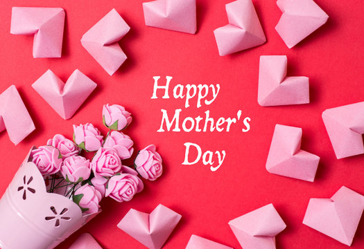 Happy Mother's Day card -  pink roses and paper hearts on red background 