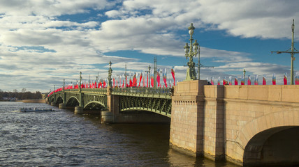 Trinity bridge in May with Victory day decorations above Neva river with pleasure boat. Blue sky with clouds. Saint Petersburg, Russia.