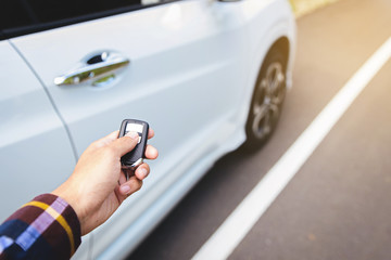 Men on hipster shirt, hand presses on the remote control car systems with sunlight along site road
