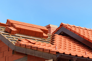 Fototapeta roof under construction with stacks of red ceramic roof tiles ready to fasten obraz