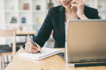 Business woman working on desk with laptop computer,Business woman using pen for note to do list...