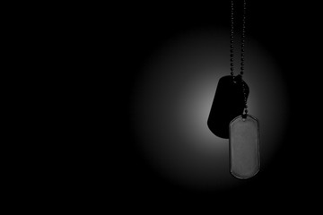 Military ID tags on a dark background