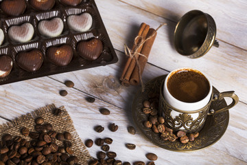 Turkish coffee with chocolate and traditional copper serving set on wooden