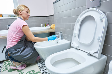 Cleaning service. woman clean toilet sink