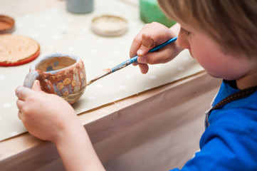 small boys make a product made of ceramics 