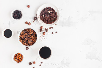 Cups of coffee, chocolate cake, chocolate muesli on white background. Flat lay, top view, copy space